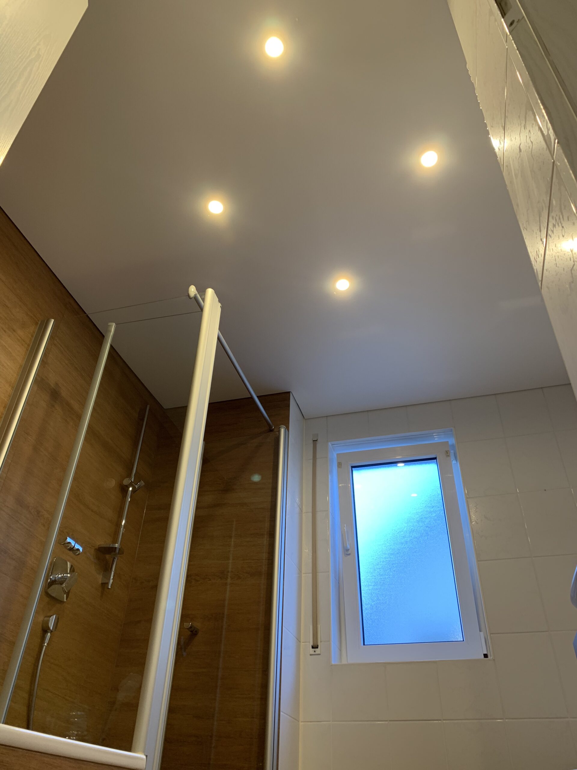 Matte Spanndecke in weiß mit vier Einbaustrahlern in einem Bad.