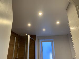 Matte Spanndecke in weiß mit vier Einbaustrahlern in einem Bad.