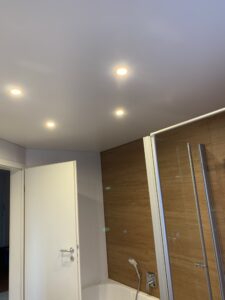 Matte Spanndecke in weiß mit vier Einbaustrahlern in einem Bad.