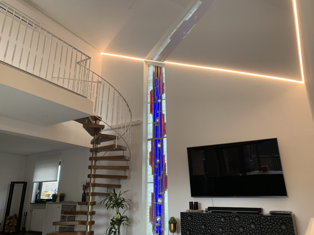 Weiße Lackspanndecke mit umlaufender LED-Beleuchtung in einem Wohnzimmer.