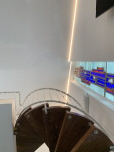 Weiße Lackspanndecke mit umlaufender LED-Beleuchtung in einem Wohnzimmer.