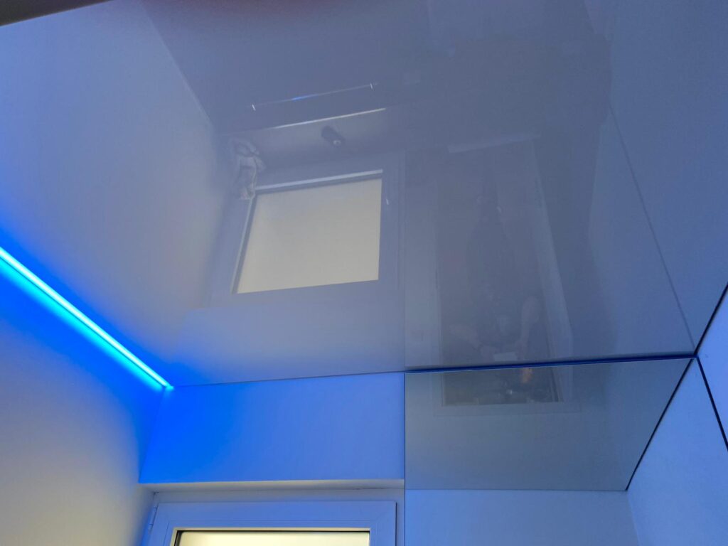 Weiße Lackspanndecke ersetzt eine Betondecke mit RGB-LED Beleuchtung.