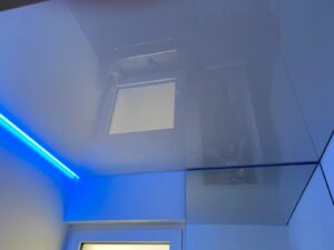 Weiße Lackspanndecke ersetzt eine Betondecke mit RGB-LED Beleuchtung.