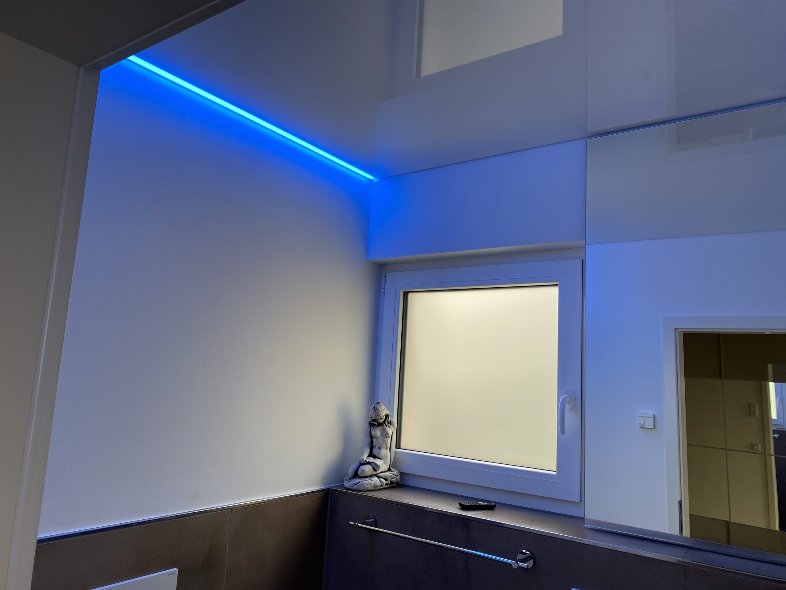 Weiße Lackspanndecke ersetzt eine Betondecke mit RGB-LED Beleuchtung.