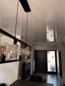 Weiße Lackspanndecke im Esszimmer und Eingangsbereich mit Deckenleuchte und Einbaustrahler.