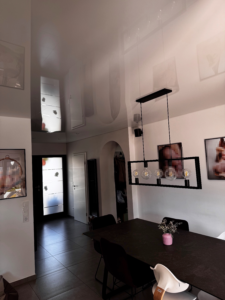 Weiße Lackspanndecke im Esszimmer und Eingangsbereich mit Deckenleuchte und Einbaustrahler.