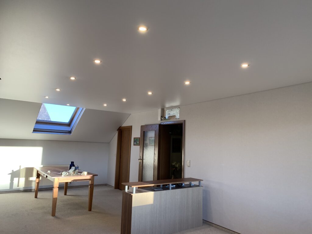 1_OS_Satin_Spanndecke_LED-Einbaustrahler_Trebur Weiße Satin Spanndecke mit LED-Einbaustrahler in einem Ess- und Wohnzimmer mit Dachschräge in Trebur