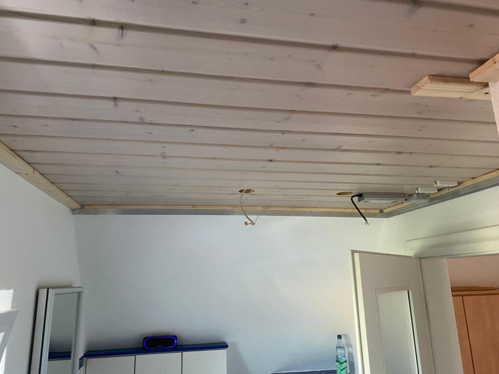 1_Vorher_Bad_Deckenpaneele Decke vor Montage eine weißen Lackpanndecke mit neutralweißer LED-Beleuchtung in der Schattenfuge in einem Bad