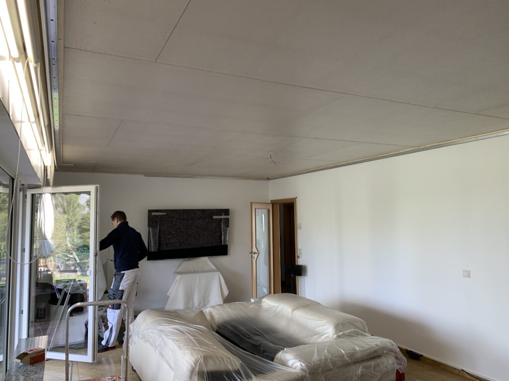 1_Vorher_Wohnzimmer_Deckenplatten Decke vor Montage eine weißen Lackspanndecke mit RGBW LED-Beleuchtung in der Schattenfuge in einem Wohnzimmer