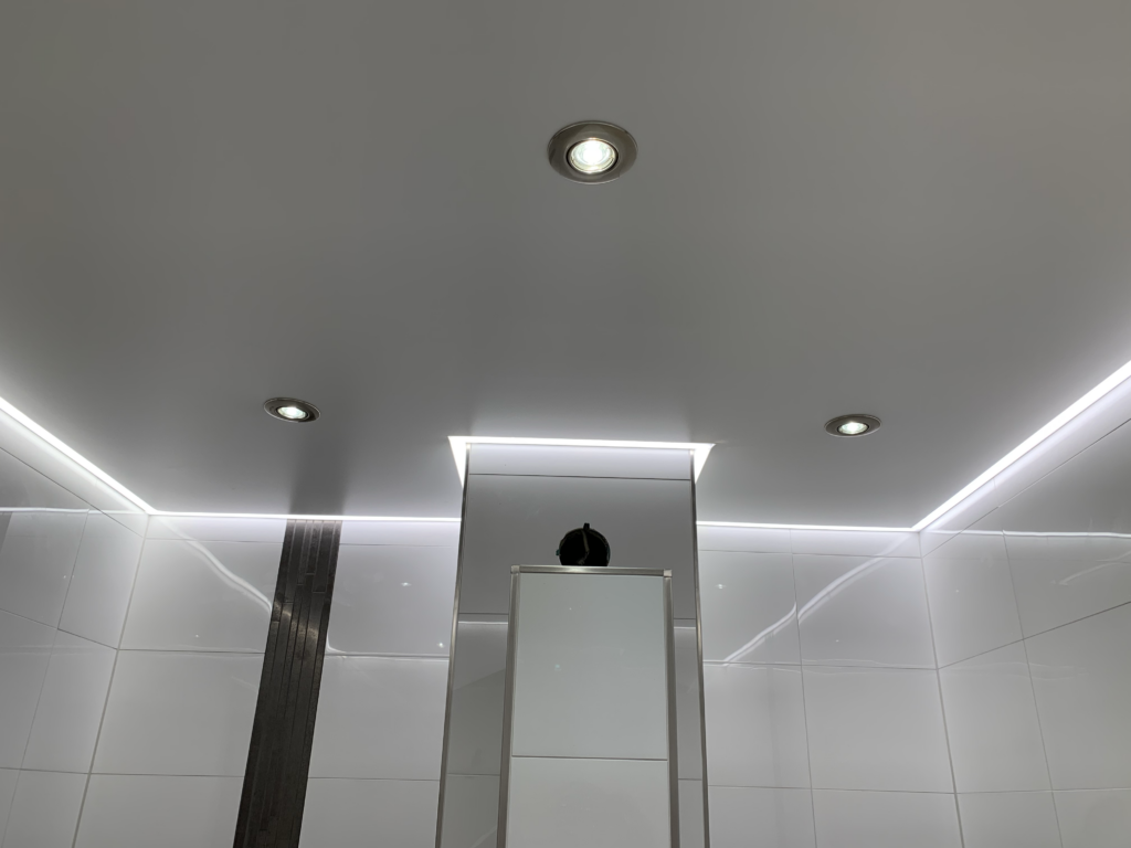 2_Lackspanndecke_LED_Einbaustrahler_LED_Beleuchtung_Bad_Rüsselsheim Weiße Lackspanndecke mit neutralweißer LED-Beleuchtung in der Schattenfuge und LED-Einbaustrahler in einem Bad in Bauschheim