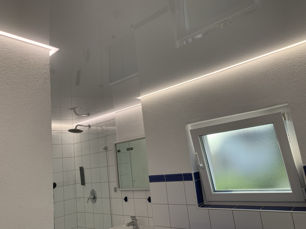 2_Lackspanndecke_weiß_Bad_LED_Beleuchtung_Trebur Weiße Lackspanndecke mit neutralweißer LED-Beleuchtung in der Schattenfuge in einem Bad