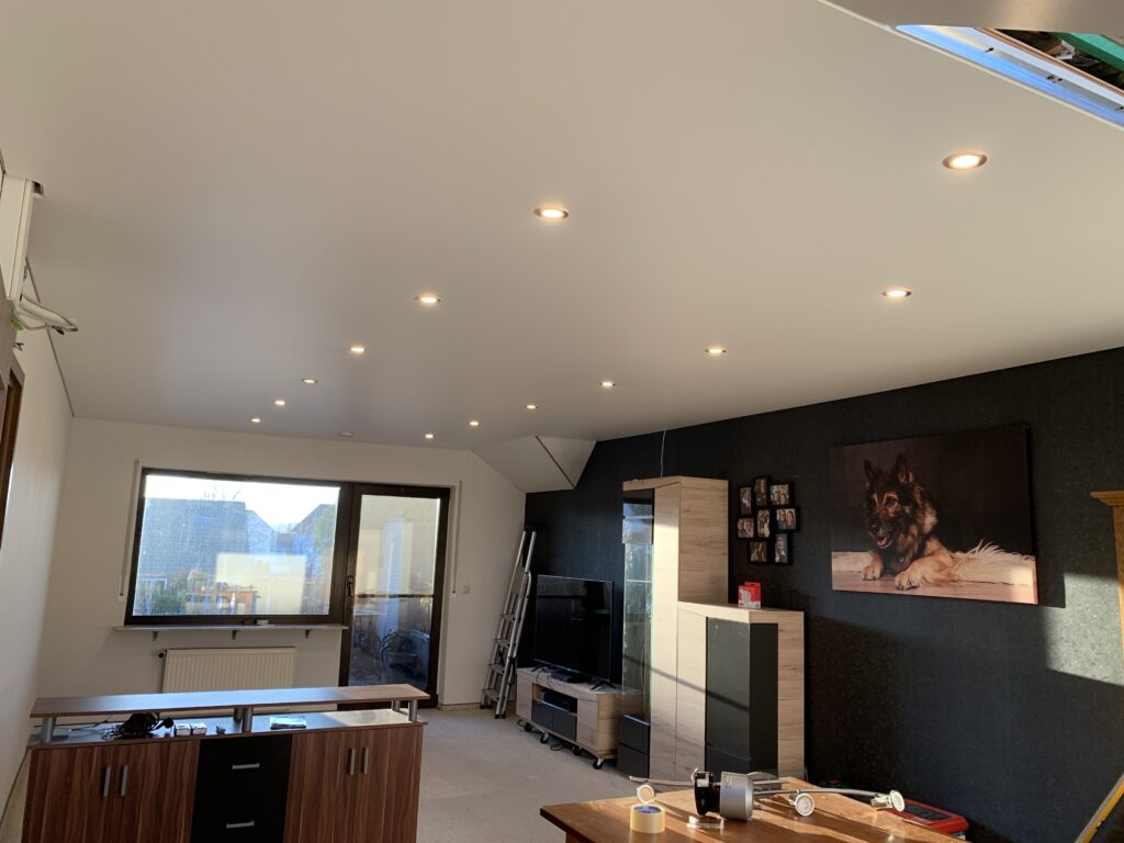 3_OS_Satin_Spanndecke_LED-Einbaustrahler_Trebur Weiße Satin Spanndecke mit LED-Einbaustrahler in einem Ess- und Wohnzimmer mit Dachschräge in Trebur