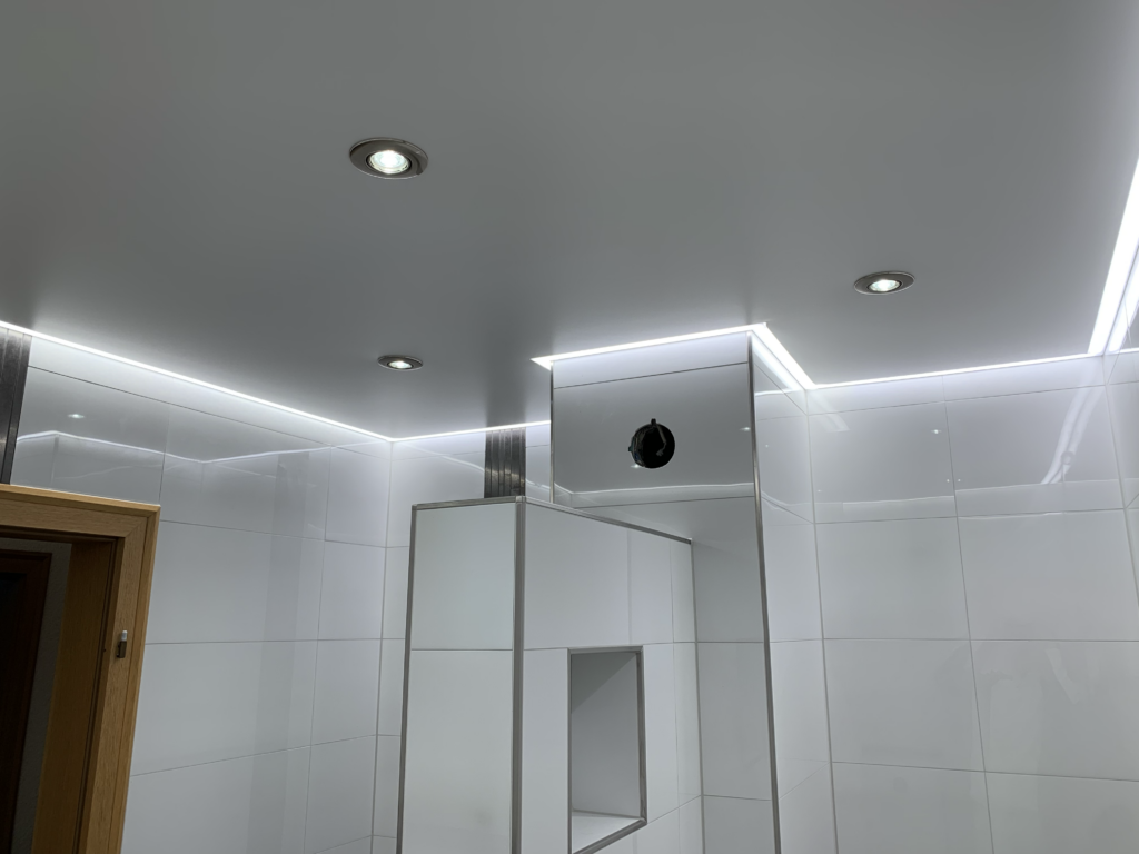 4_Lackspanndecke_LED_Einbaustrahler_LED_Beleuchtung_Bad_Rüsselsheim Weiße Lackspanndecke mit neutralweißer LED-Beleuchtung in der Schattenfuge und LED-Einbaustrahler in einem Bad in Bauschheim
