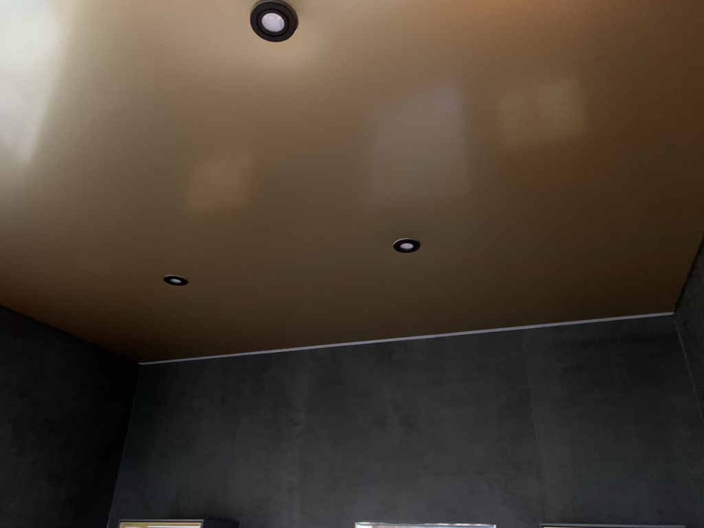 4_Spanndecke_Gold_metallic_LED-Beleuchtung_Schattenfuge_LED_Einbaustrahler_Darmstadt Spanndecke in Gold Metallic mit warmweißer LED-Beleuchtung in der Schattenfuge und LED Einbaustrahler in einer Fliesenausstellung in Darmstadt