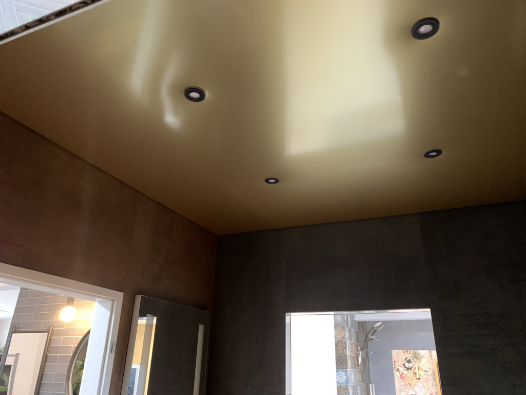 5_Spanndecke_Gold_metallic_LED-Beleuchtung_Schattenfuge_LED_Einbaustrahler_Darmstadt Spanndecke in Gold Metallic mit warmweißer LED-Beleuchtung in der Schattenfuge und LED Einbaustrahler in einer Fliesenausstellung in Darmstadt