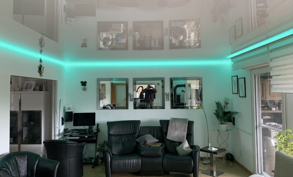 6_Lackspanndecke_Weiß_Indirekte_Beleuchtung_RGBW_Trebur Weiße Lackspanndecke mit RGBW LED-Beleuchtung in einem Wohnzimmer
