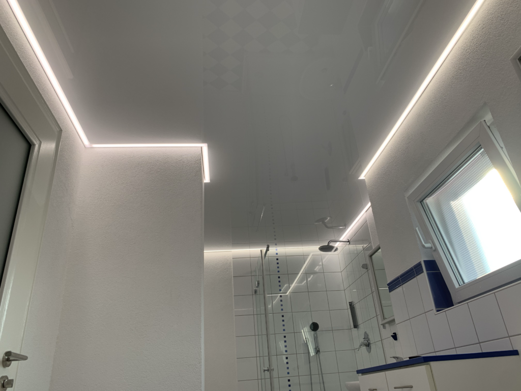6_Lackspanndecke_weiß_Bad_LED_Beleuchtung_Trebur Weiße Lackspanndecke mit neutralweißer LED-Beleuchtung in der Schattenfuge in einem Bad