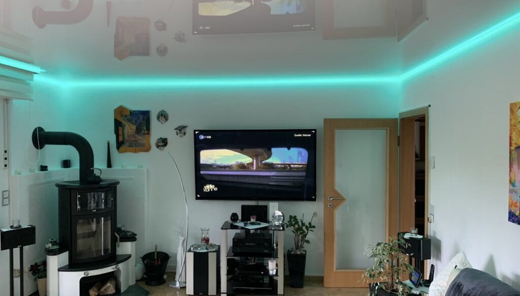 7_Lackspanndecke_Weiß_Indirekte_Beleuchtung_RGBW_Trebur Weiße Lackspanndecke mit RGBW LED-Beleuchtung in einem Wohnzimmer
