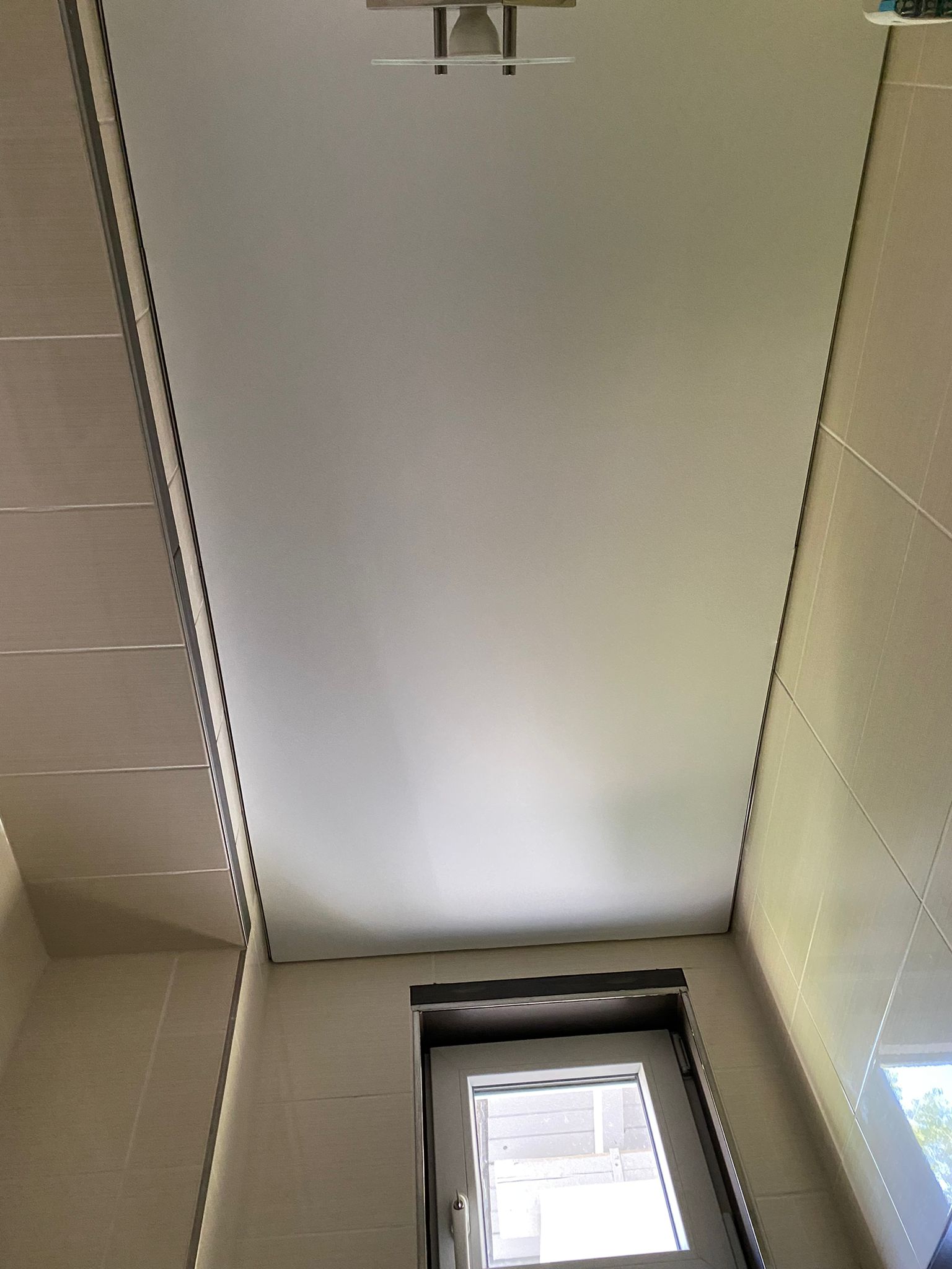 Bedruckte Lichtdecke im ausgeschaltetem Zustand. Sichtbar ist eine weiße Satin Spanndecke in einem Gäste-WC in Nauheim.