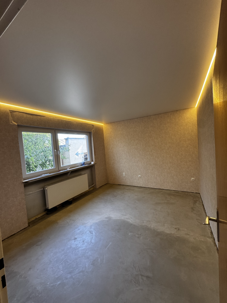 Weißes Esszimmer in Trebur mit matter Spanndecke und warmweißer LED-Beleuchtung in der Schattenfuge auf zwei Seiten.